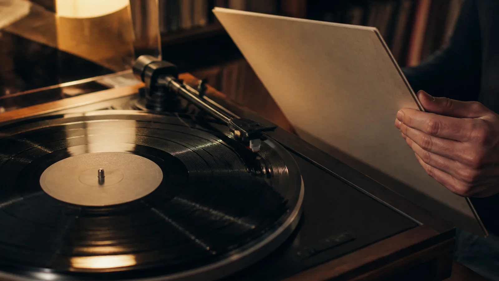 Vinilna ploča na gramofonu uz otvoreni omot albuma